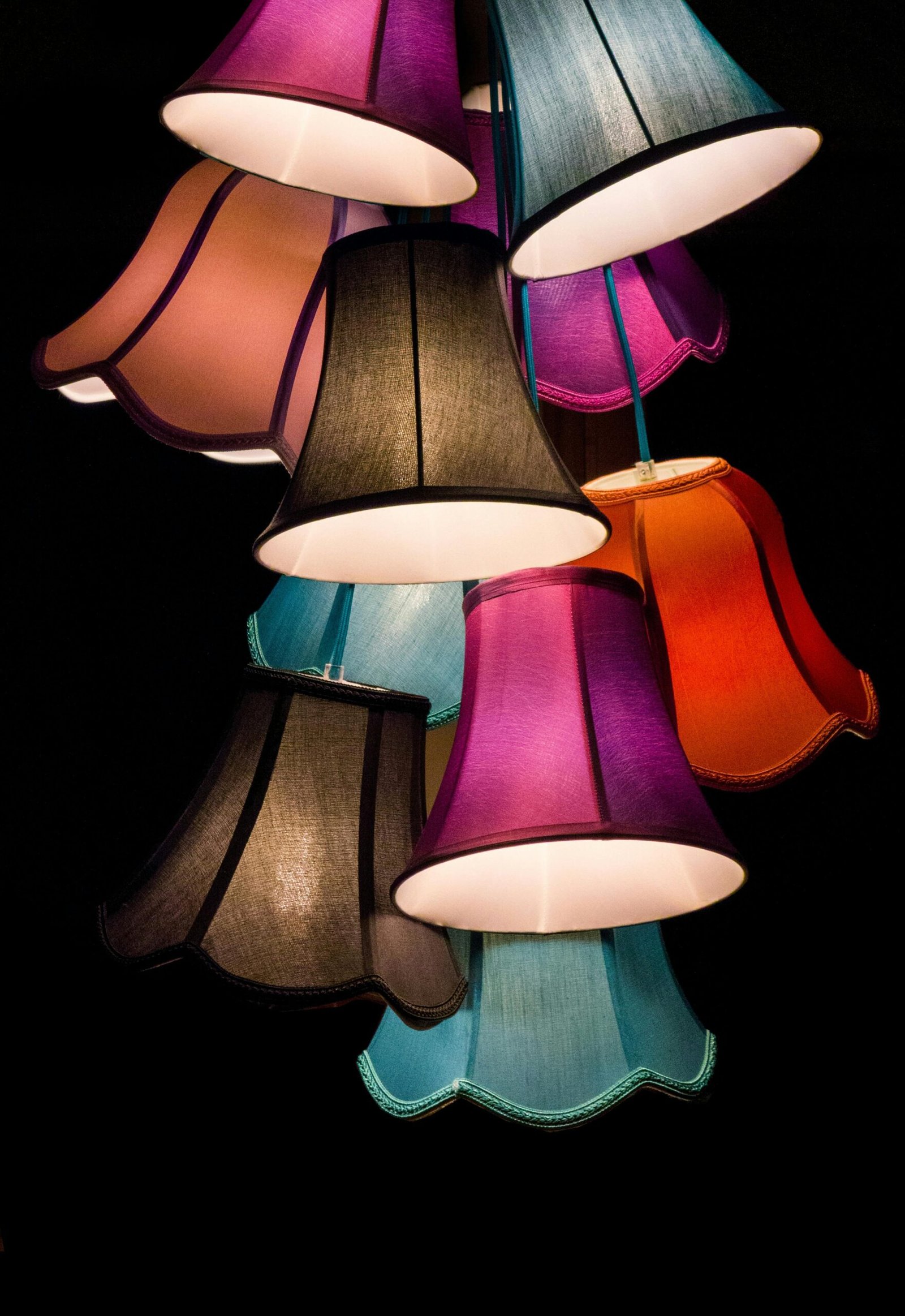 A bold display of colorful lampshades creating an artistic light fixture indoors.